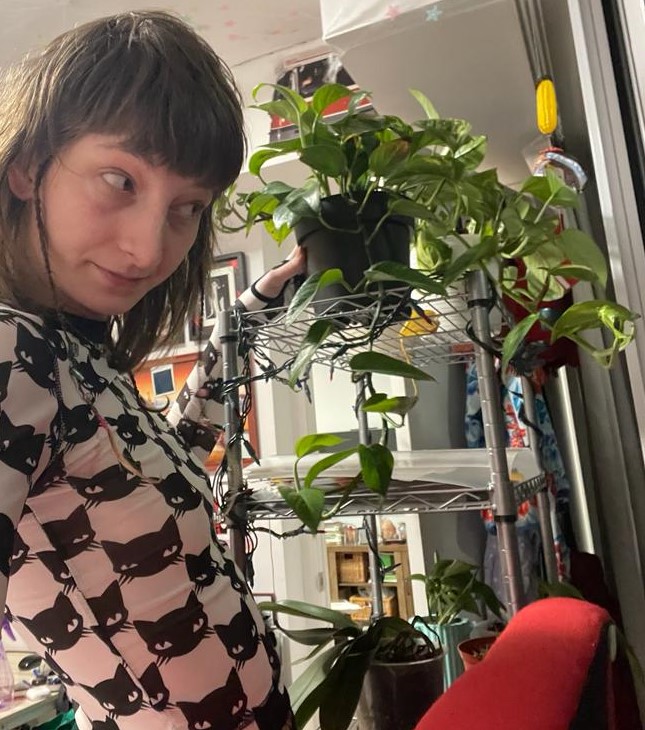 This is a selfie of me and my one-year-old Pothos plant I am currently most proud of and was the start of the indoor planting journey. Green thumb, green mind